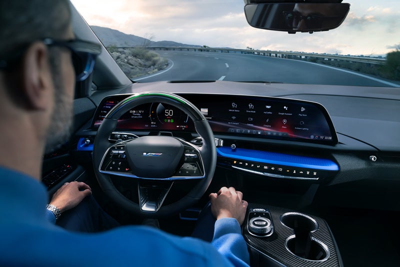 Front View of the 2026 OPTIQ-V Driving Through the Dusk Utilizing its Headlights | Fitzgerald Cadillac Annapolis in Annapolis MD