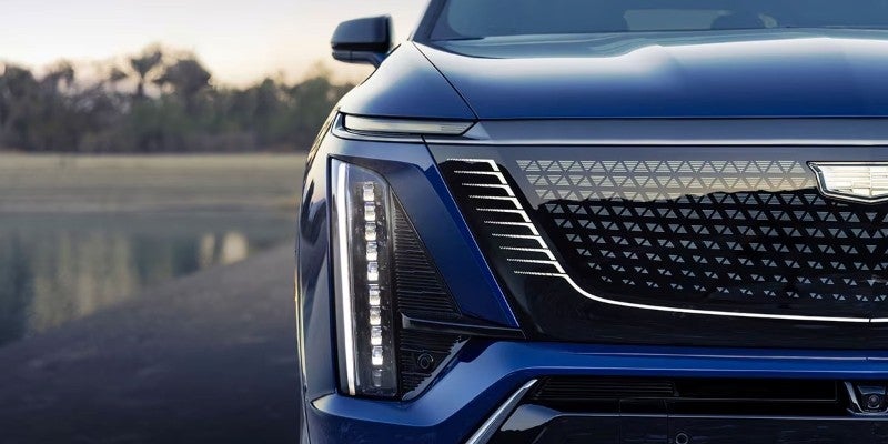 Close-up of the 2026 Cadillac VISTIQ front grille and vertical LED headlight design.