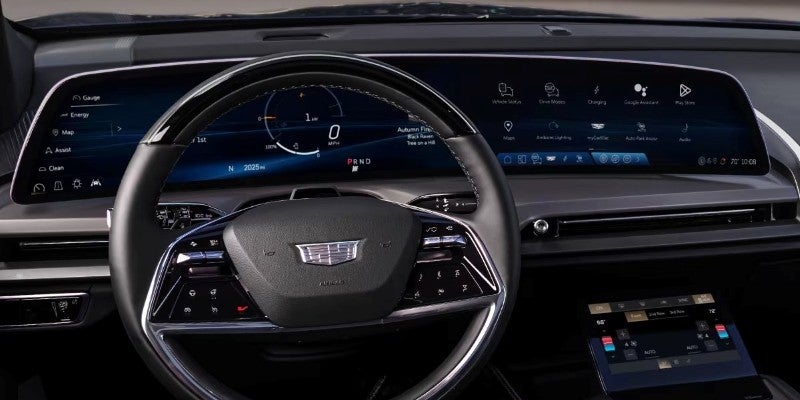 2026 Cadillac VISTIQ interior featuring digital instrument cluster, wide curved infotainment screen, and leather-wrapped steering wheel.